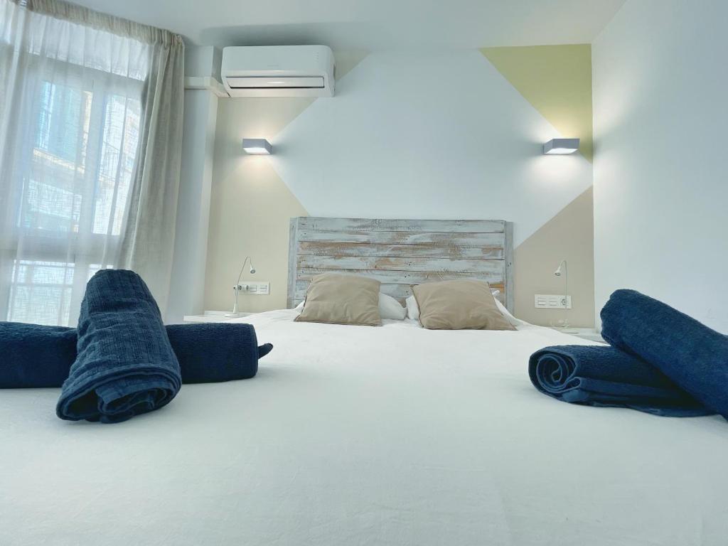 a bedroom with a large white bed with blue pillows at Apartamento Soho Malaga in Málaga