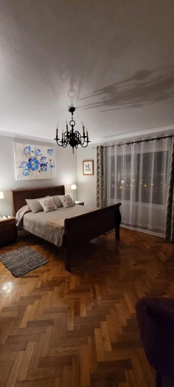 Un dormitorio con una cama grande y una lámpara de araña. en CasaMatta en Viña del Mar