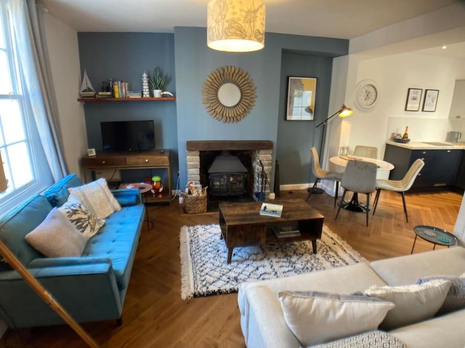 a living room with a blue couch and a table at Cosy 2 bedroom cottage in Scarborough's Old Town in Scarborough