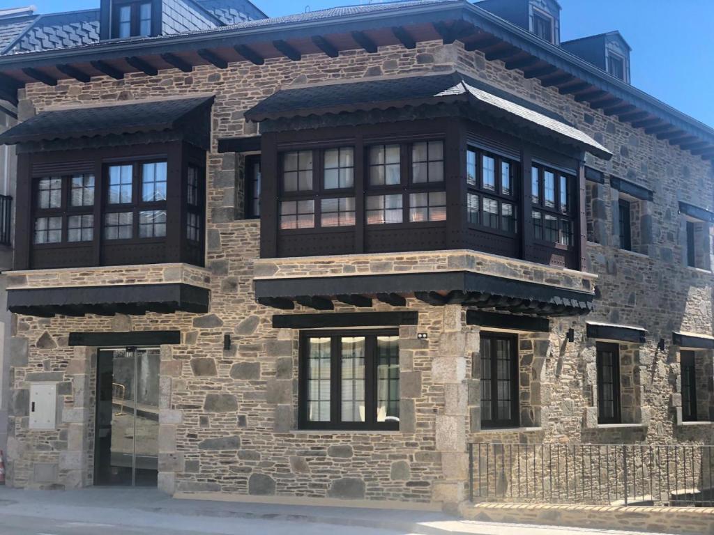 a large brick building with black windows on it at VILLA DOS INFANTAS in Puebla de Sanabria