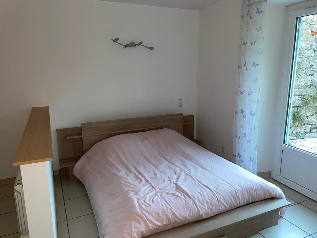 a bedroom with a bed in a room with a window at Studio 4 couchages avec terrasse proximité du lac in Clairvaux-les-Lacs