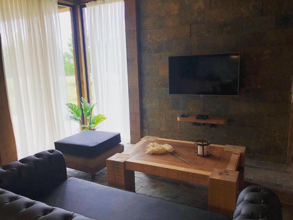 a living room with a coffee table and a tv at Noha Casa de Campo in Colón