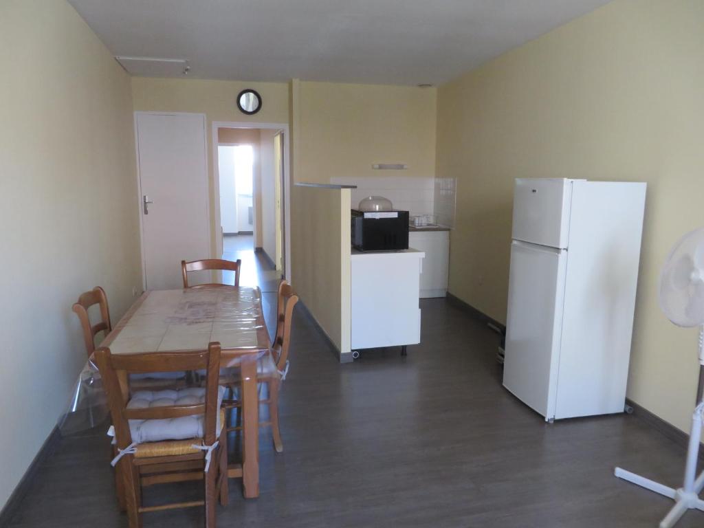 cocina y comedor con mesa y nevera en appartement 4 à 6 couchages, en Clairvaux-les-Lacs