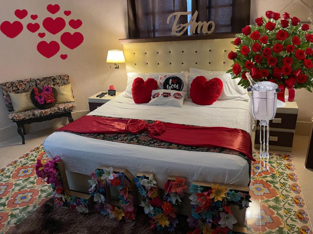 a bedroom with a bed with hearts on the wall at La casa del colibrí in Campeche