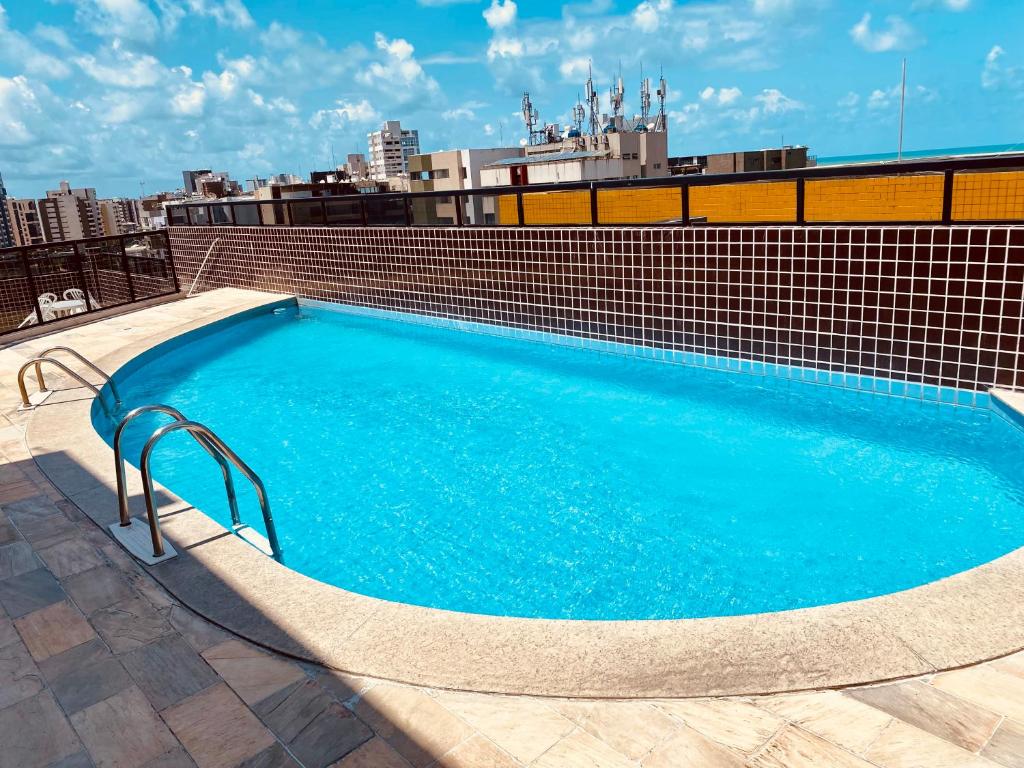 een groot blauw zwembad bovenop een gebouw bij Perto da Praia e Piscina na cobertura in Maceió