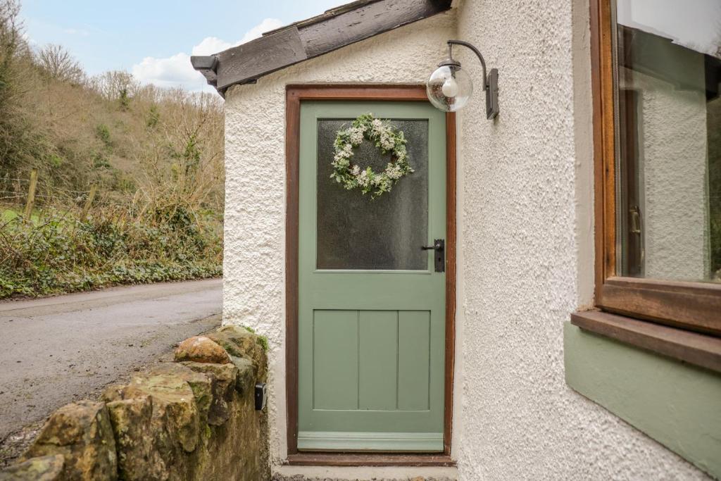 Una porta per una casa con una corona di fiori di Camerton Hall Cottage a Workington