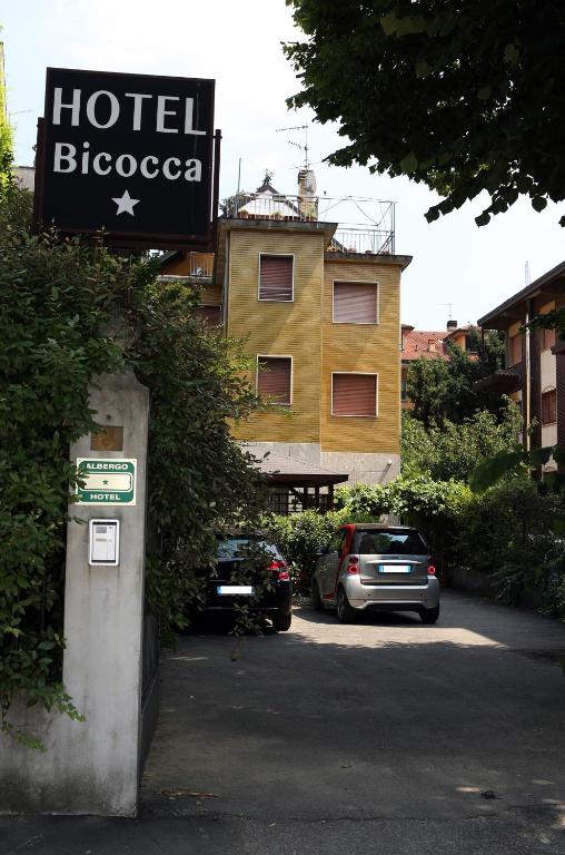 hotel biococo sign i samochody zaparkowane na parkingu w obiekcie Hotel Bicocca w Mediolanie