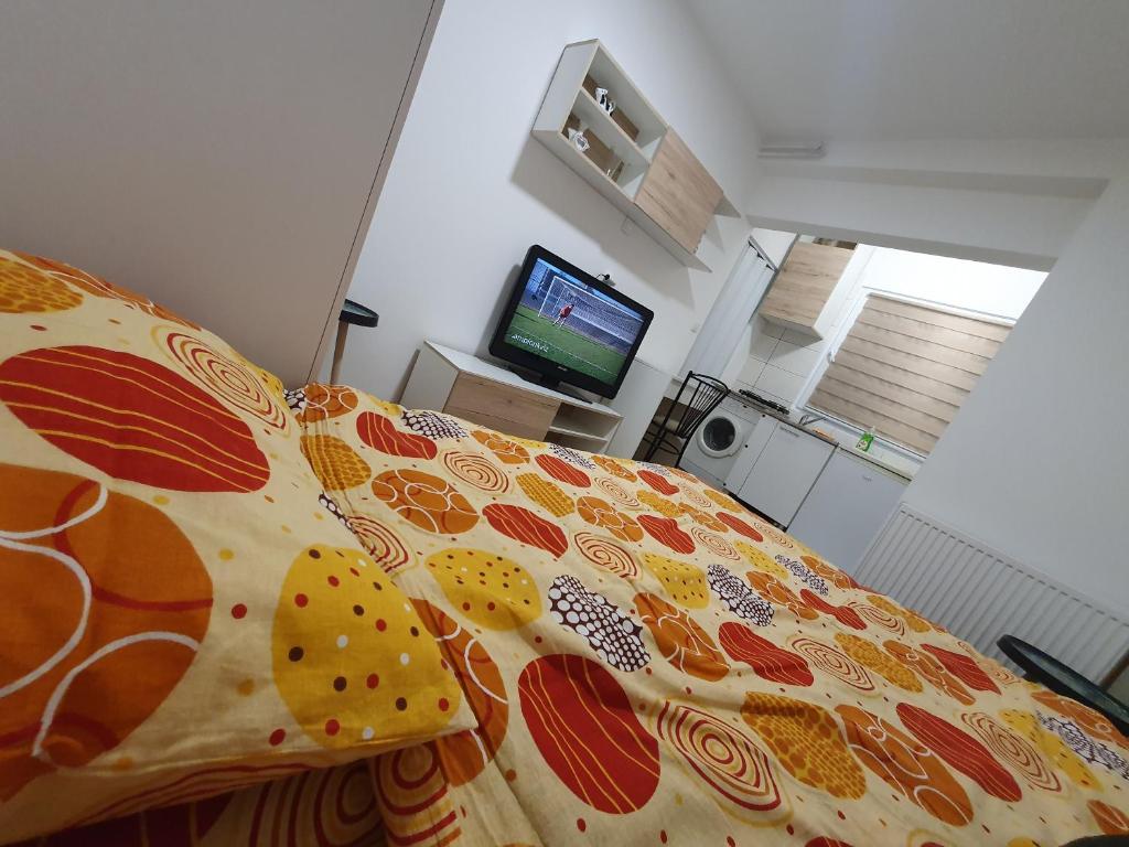 1 dormitorio con 1 cama con colcha colorida en Garsonjera u centru Prnjavor en Prnjavor