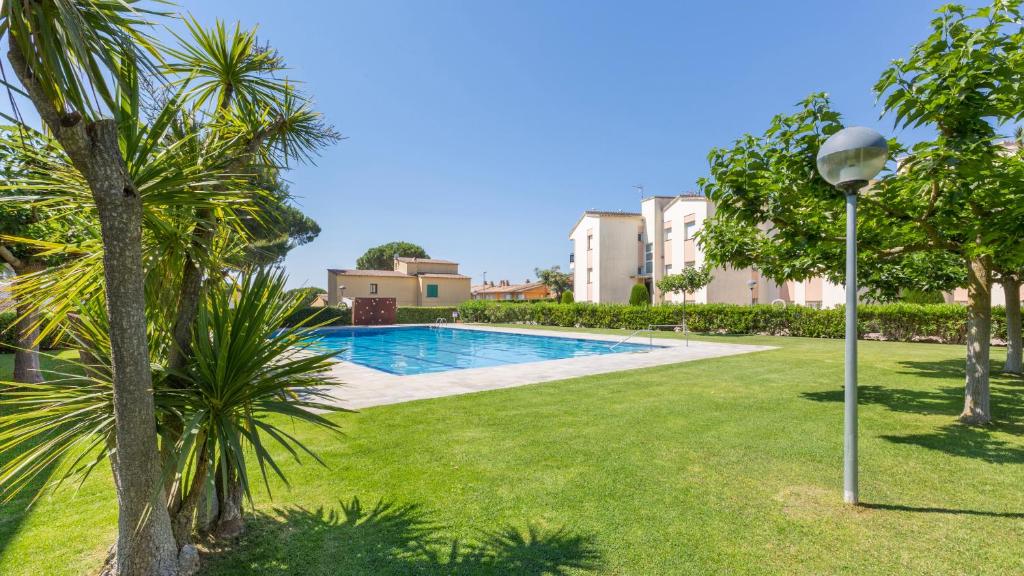 einen Pool in einem Garten mit Palmen und Straßenbeleuchtung in der Unterkunft CB K-2 - Calella de Palafrugell in Calella de Palafrugell