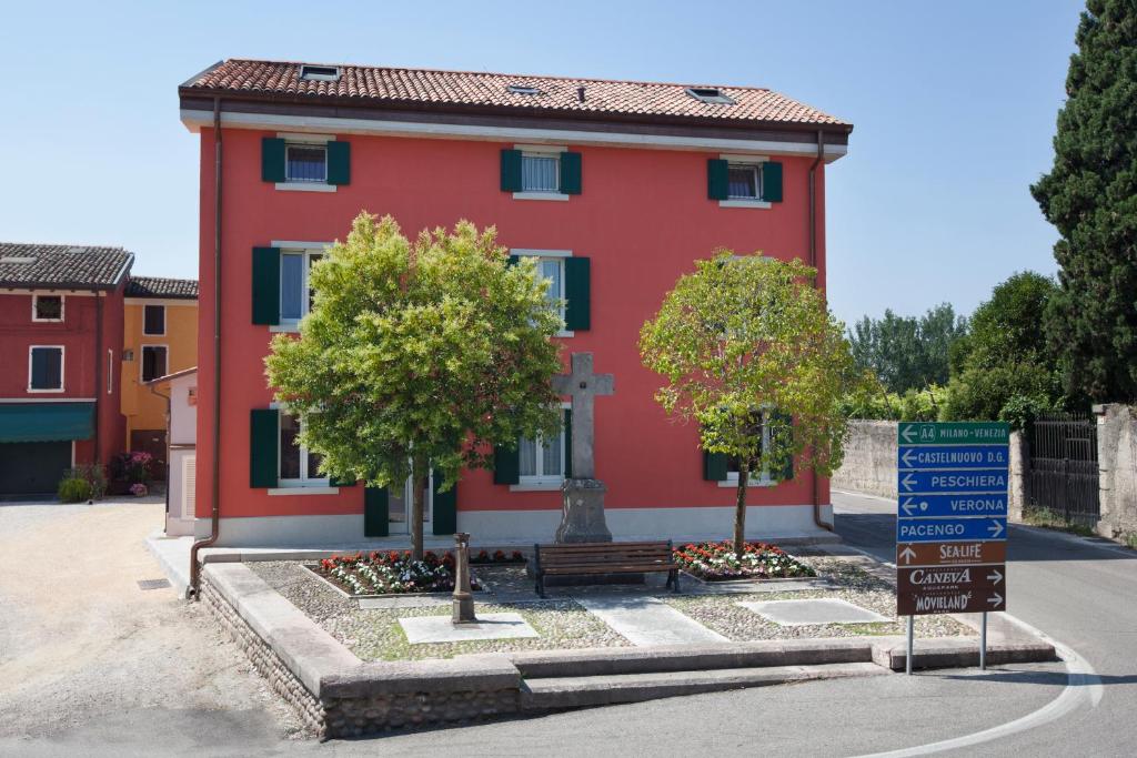 a red house with a street sign in front of it at Appartamenti al Canton in Colà di Lazise