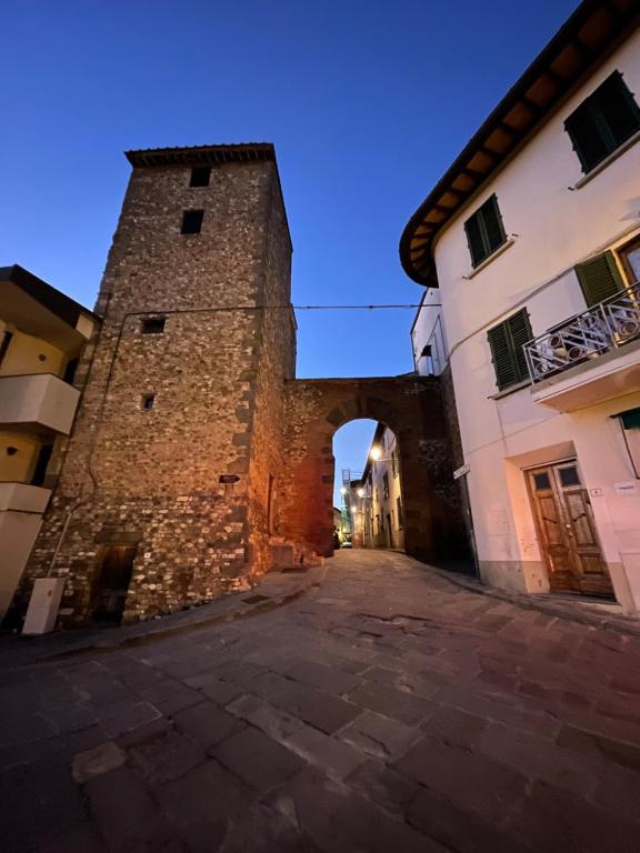 una entrada a un edificio con un arco en una calle en Porta del Chianti Tuscany Apartment, en San Casciano in Val di Pesa