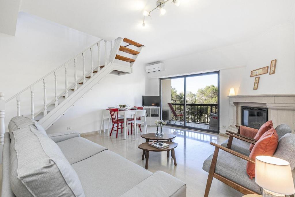 un soggiorno con divano e tavolo di Guia Alamos Duplex Apartment a Cascais