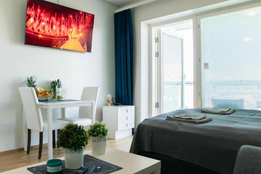 a bedroom with a bed and a table and a desk at City center brand new studio, parking in Oulu