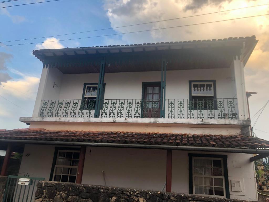 Cette maison blanche dispose d'un balcon. dans l'établissement Casa Vista para Serra, à Tiradentes