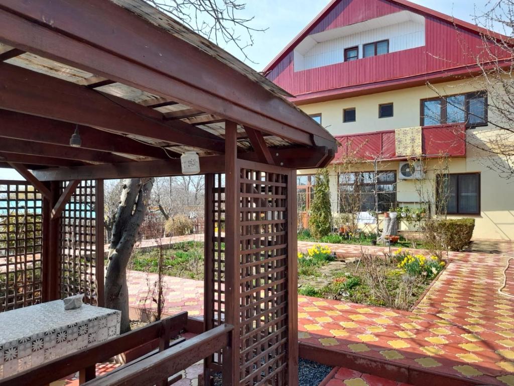 a wooden pergola in front of a house at Pensiunea Anda in Tulcea