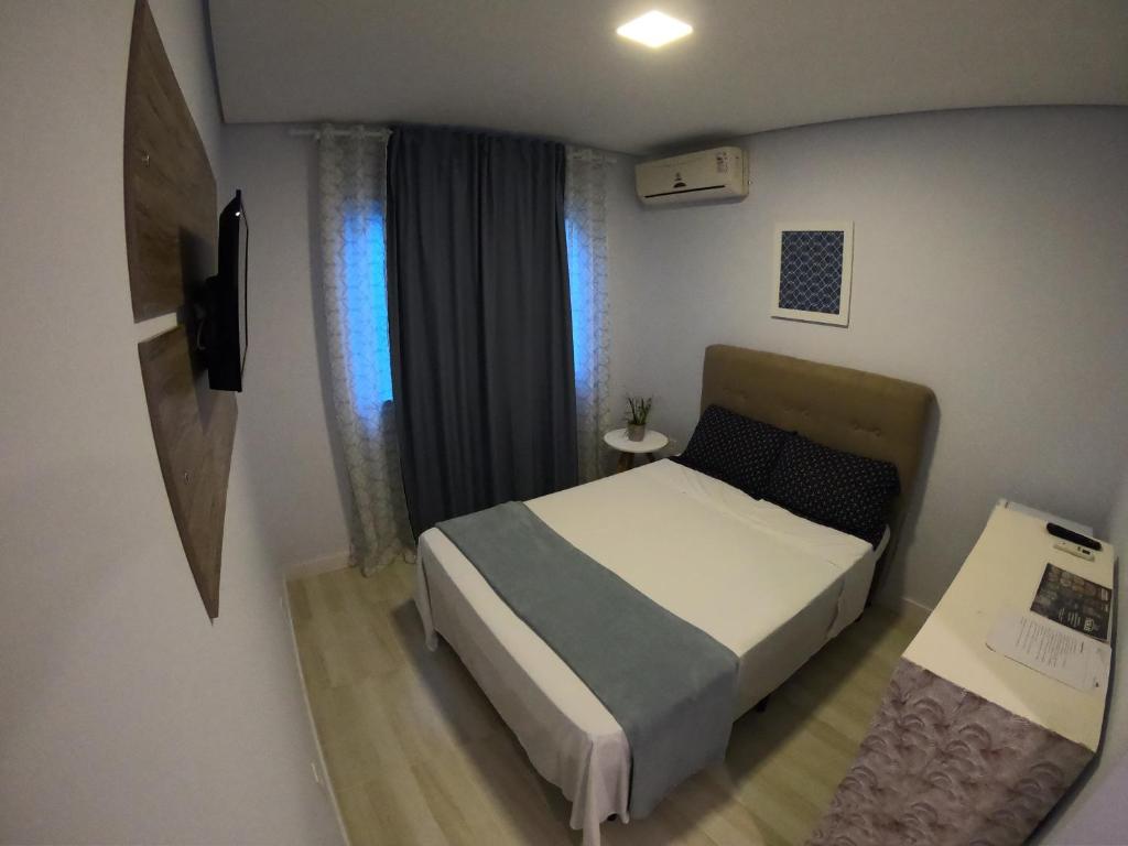 - une petite chambre avec un lit et une fenêtre dans l'établissement Hotel e Pousada Magic, à Penha