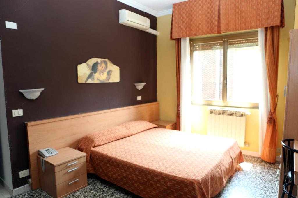 Hotel Bicocca في ميلانو: غرفة نوم صغيرة بها سرير ونافذة
