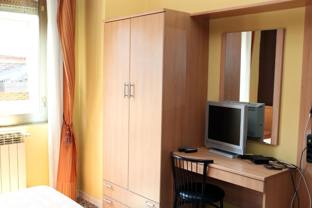 sypialnia z biurkiem, telewizorem i lustrem w obiekcie Hotel Bicocca w Mediolanie
