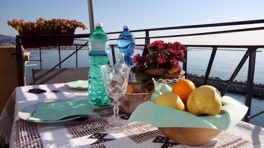 un tavolo con un cesto di frutta e una bottiglia d'acqua di B&B Porta del Mare a Genova