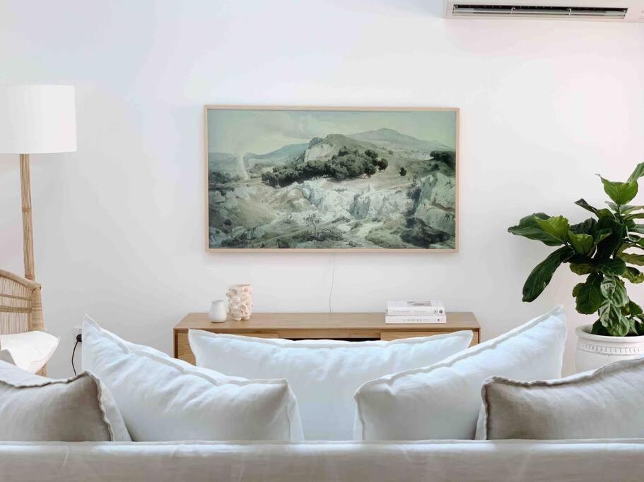a living room with a couch and a painting on the wall at Casa Parker Stunning 3bdrm apartment in Killcare in Killcare