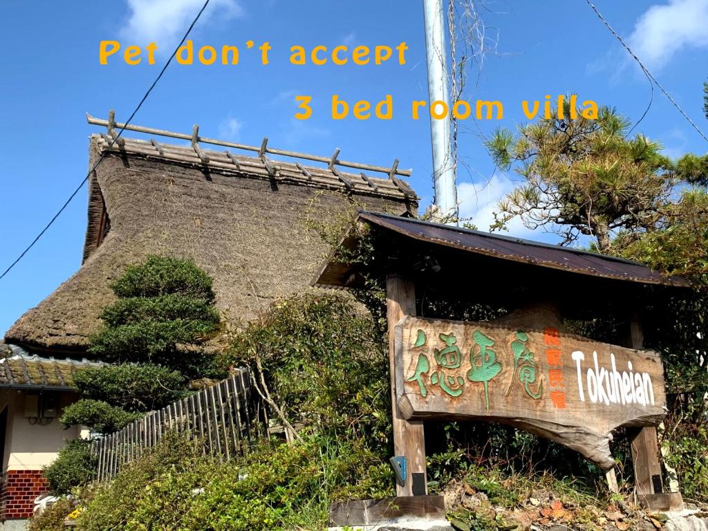 a sign in front of a building with a roof at Tokuheian in Kyoto