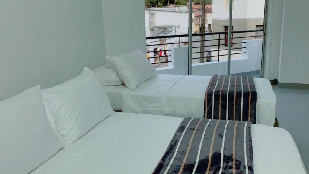 Cette chambre dispose de 2 lits et d'un balcon. dans l'établissement Aloja-T en Apartamento amoblado 4 en Ciudad Bolivar, à Ciudad Bolívar