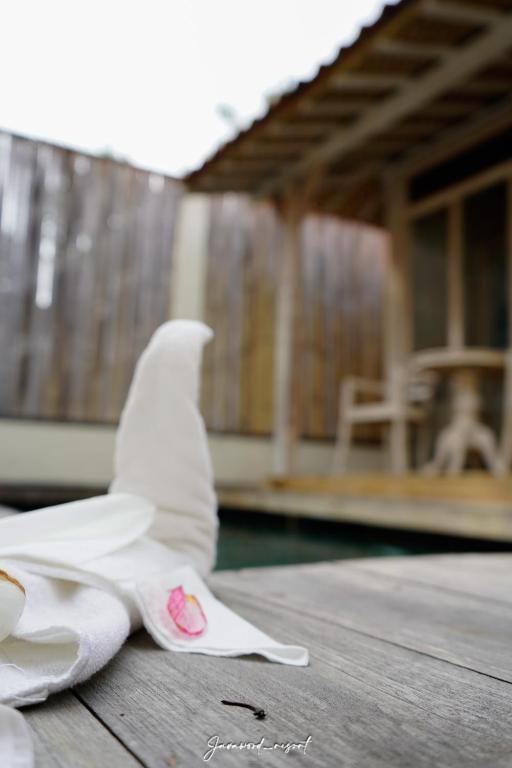 a white paper bird sitting on a wooden table at Java Wood in Gili Trawangan