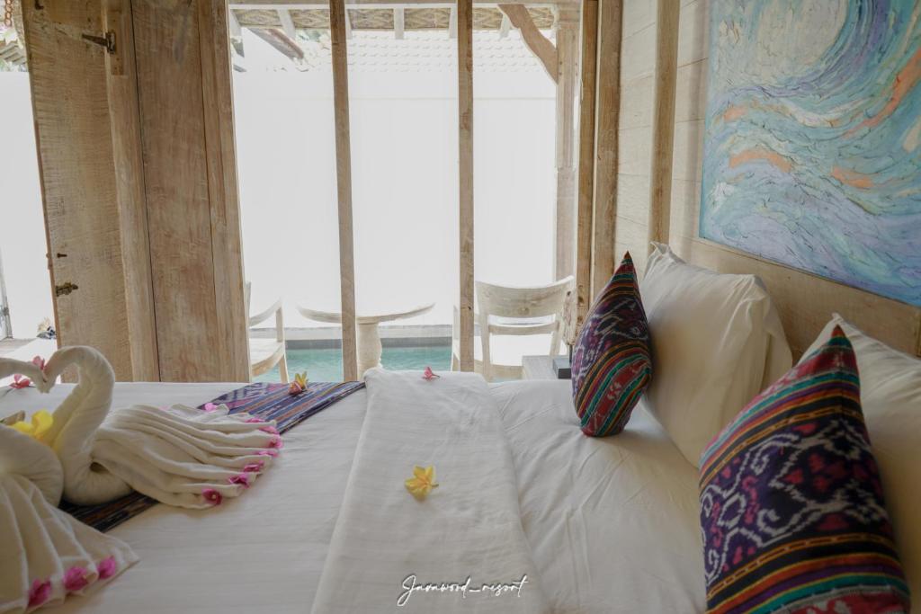 a bedroom with a bed with two swans on it at Java Wood in Gili Trawangan