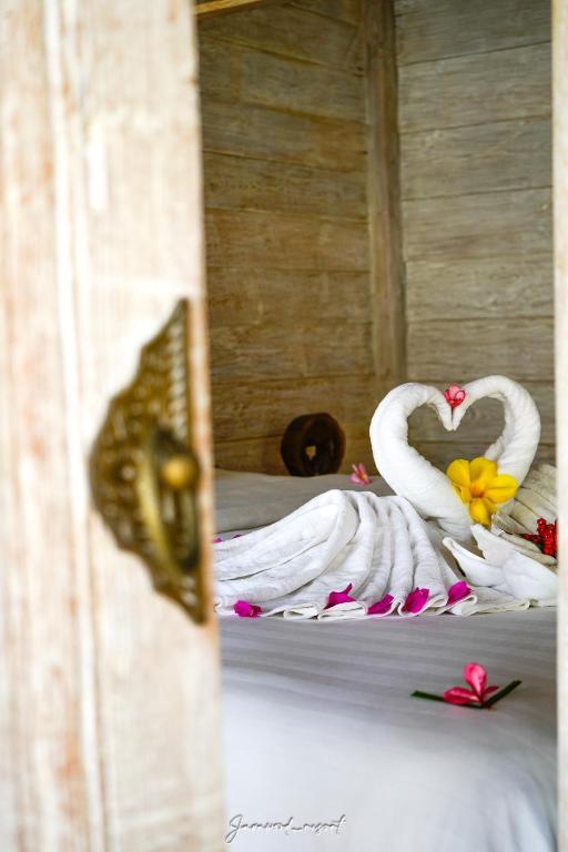 two swans made out of towels on a bed at Java Wood in Gili Trawangan