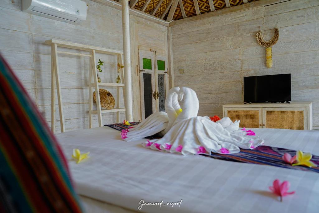 a white swan statue sitting on top of a bed at Java Wood in Gili Trawangan