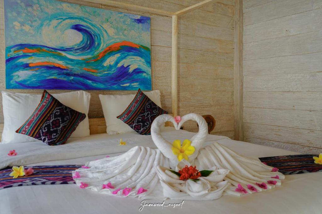 two swans are sitting on top of a bed at Java Wood in Gili Trawangan