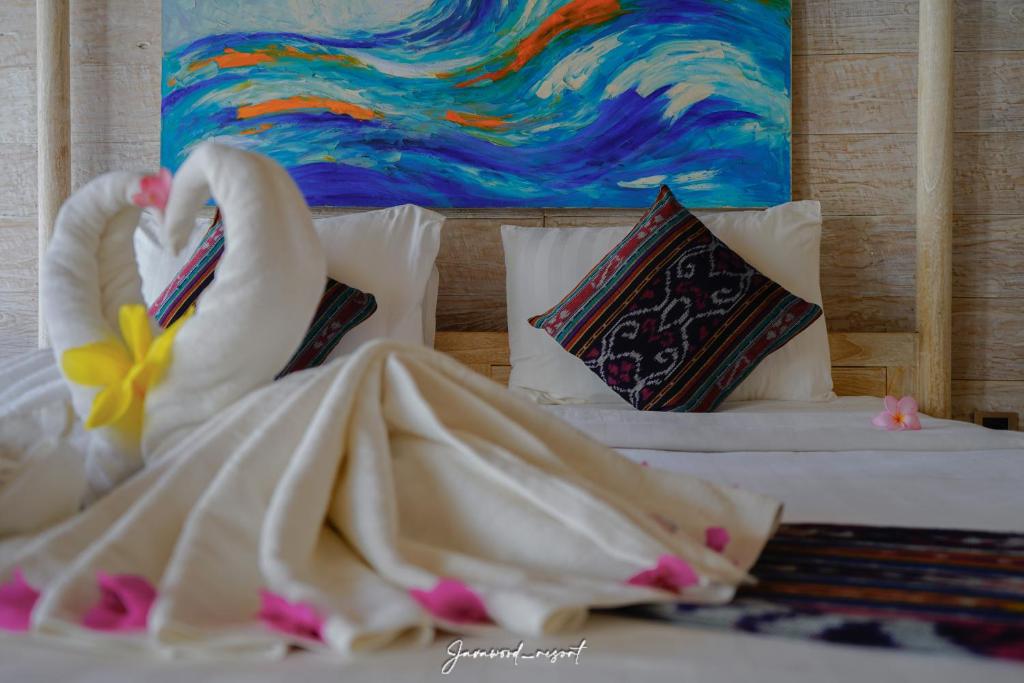 a bedroom with a bed with two swans on it at Java Wood in Gili Trawangan