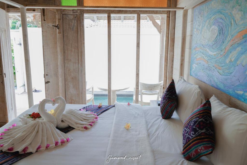 two swans are sitting on top of a bed at Java Wood in Gili Trawangan