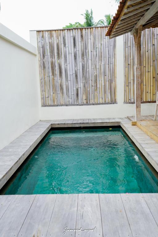 a small swimming pool in a house with a wooden floor at Java Wood in Gili Trawangan