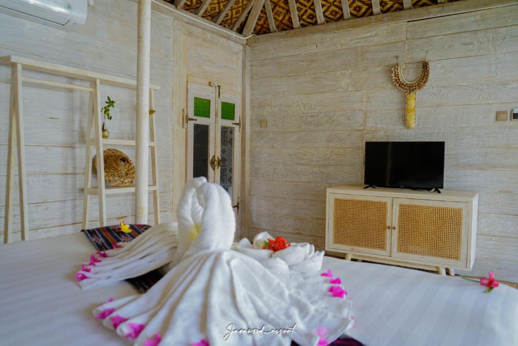 a bride in a white dress sitting on a bed at Java Wood in Gili Trawangan