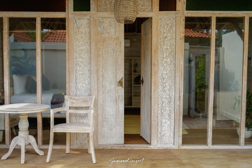 a table and two chairs in front of a building at Java Wood in Gili Trawangan