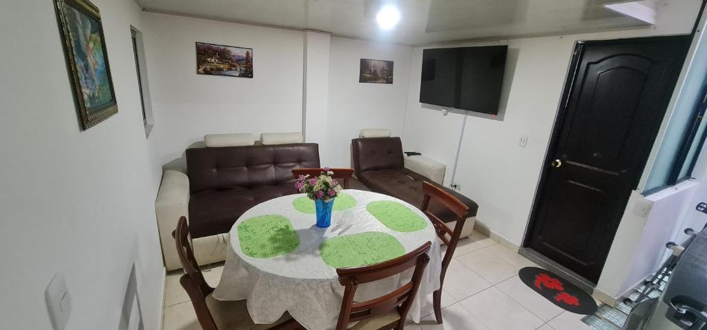 a dining room with a table and chairs and a television at Apartamento Ynj#2 in Bogotá