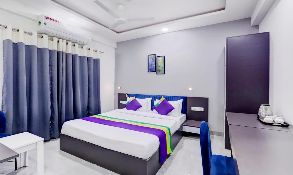 a bedroom with a king sized bed and a desk at Treebo Trend Finesta Suites, Nagpur Airport in Nagpur
