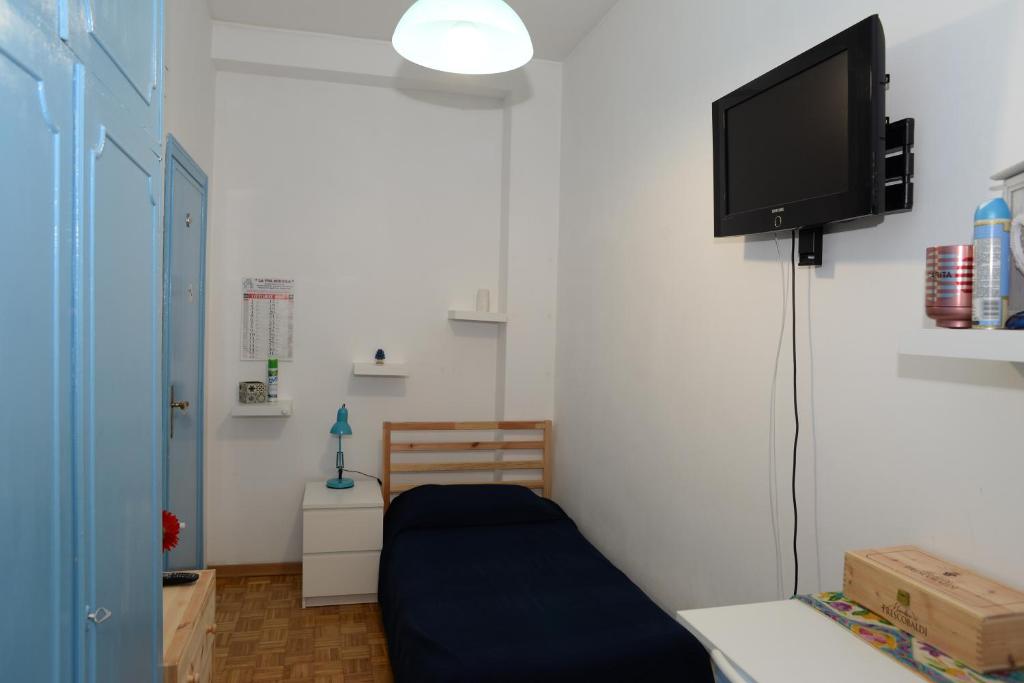 salon z telewizorem i niebieską kanapą w obiekcie Room in Guest room - Single room in cozy and comfortable apartment w Rzymie
