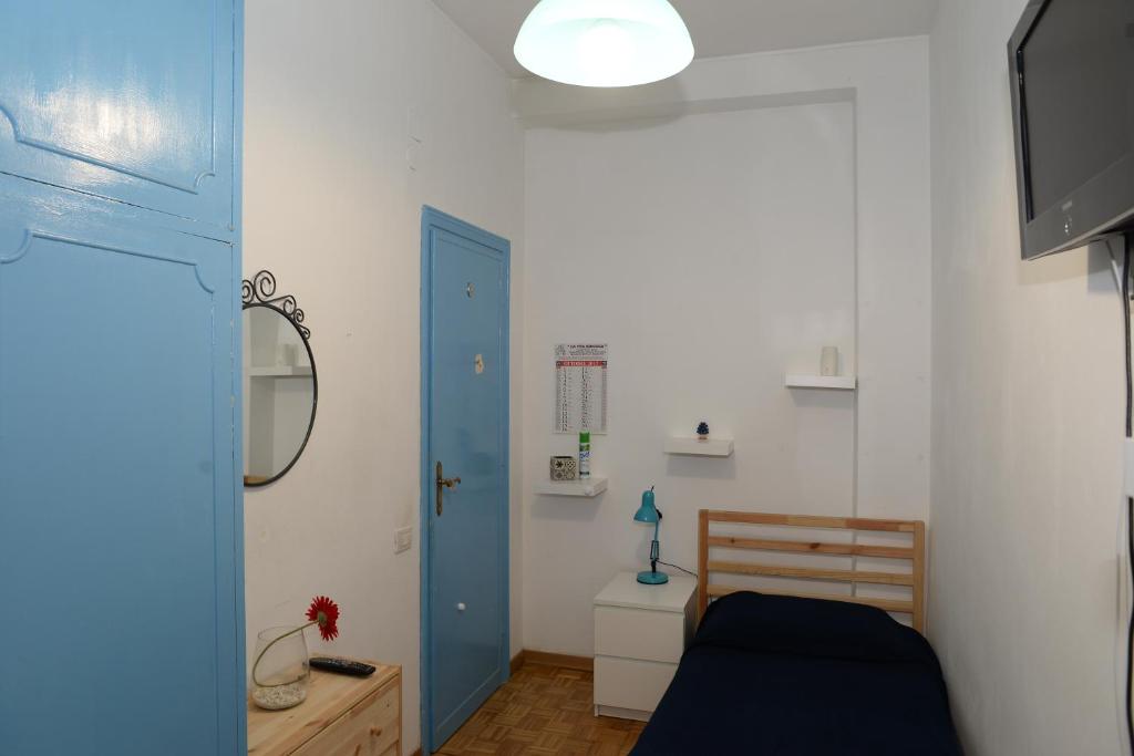 sypialnia z łóżkiem i niebieskimi drzwiami w obiekcie Room in Guest room - Single room in cozy and comfortable apartment w Rzymie