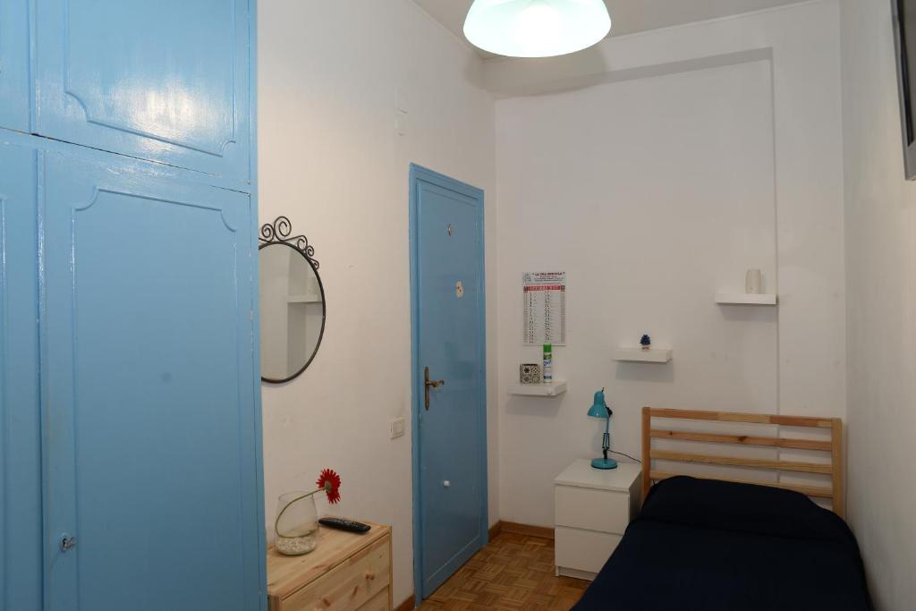 sypialnia z łóżkiem i niebieskimi drzwiami w obiekcie Room in Guest room - Single room in cozy and comfortable apartment w Rzymie