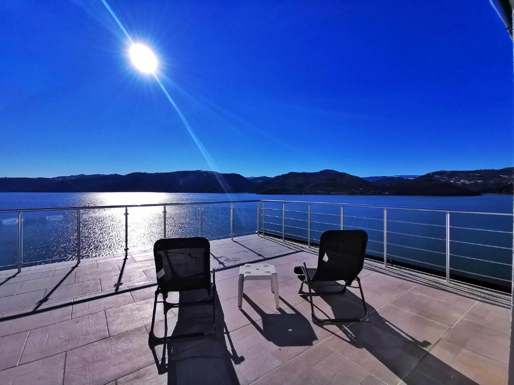 two chairs on a deck with a view of the water at Lakeview-Estate ApartHotel in Staro Myasto