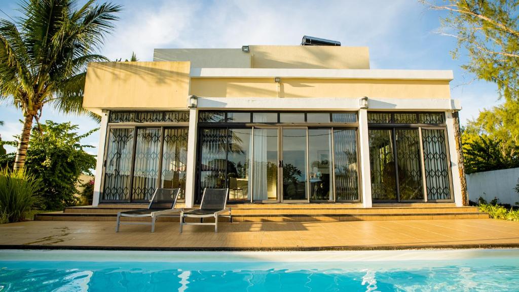 Villa Angelou - Sunlit Beach Getaway with Pool and WIFI في بيل مار: منزل بمسبح بجوار منزل