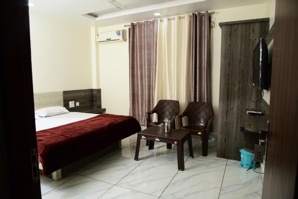 a hotel room with a bed and a chair at Sharma Guest House, Himachal Pradesh in Kangra