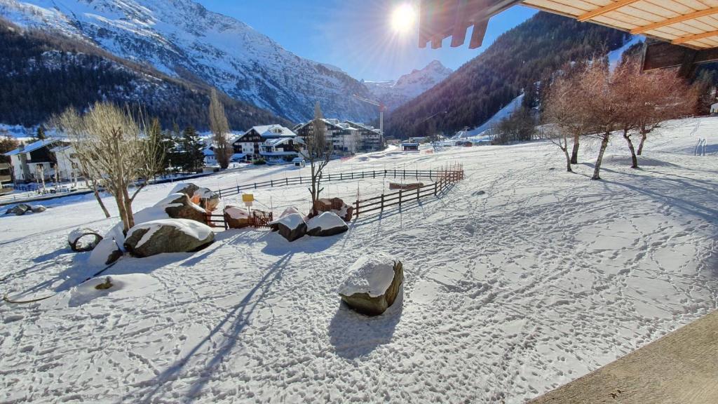 a snow covered field with mountains in the background at Appartamento condominio Ametista - La Thuile in La Thuile