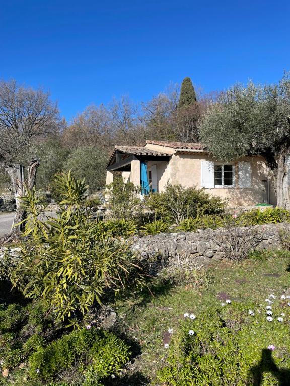 a small stone house in a garden with bushes at Villa du Sud in Vence