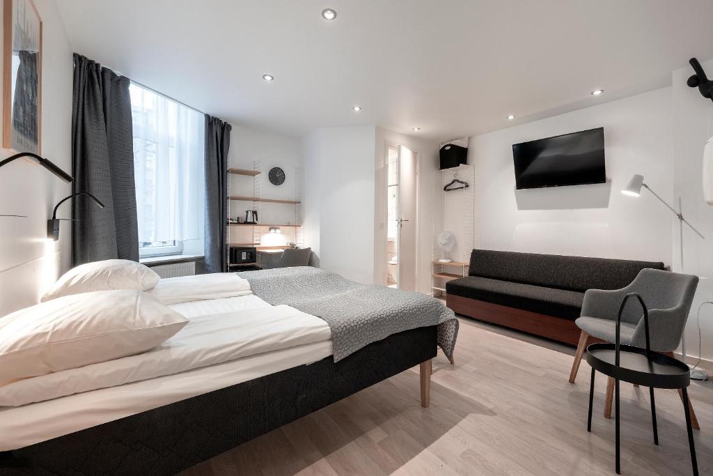 a bedroom with a large bed and a couch at Go Hotel Ansgar in Copenhagen
