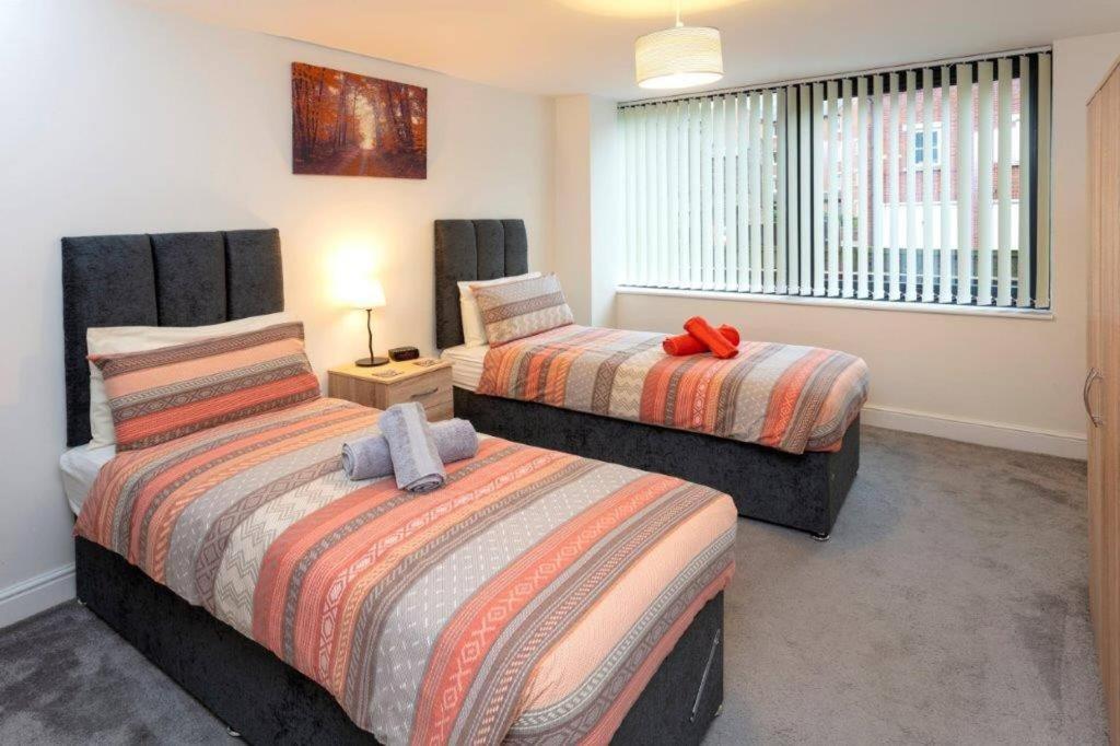 um quarto com 2 camas e uma janela em Spacious 2 Bed Apartment Norwich, Close To Station and City centre em Norwich