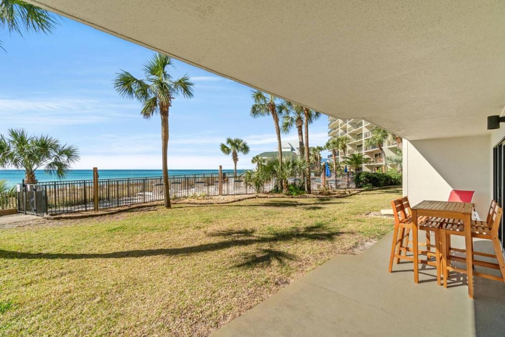 パナマ・シティ・ビーチにあるCommodore 103の海とヤシの木の景色を望むパティオ