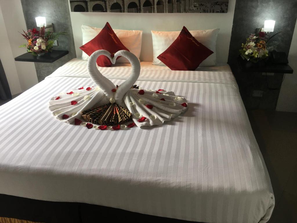 two swans made out of candy canes on a bed at The Front Hotel and Apartments in Patong Beach